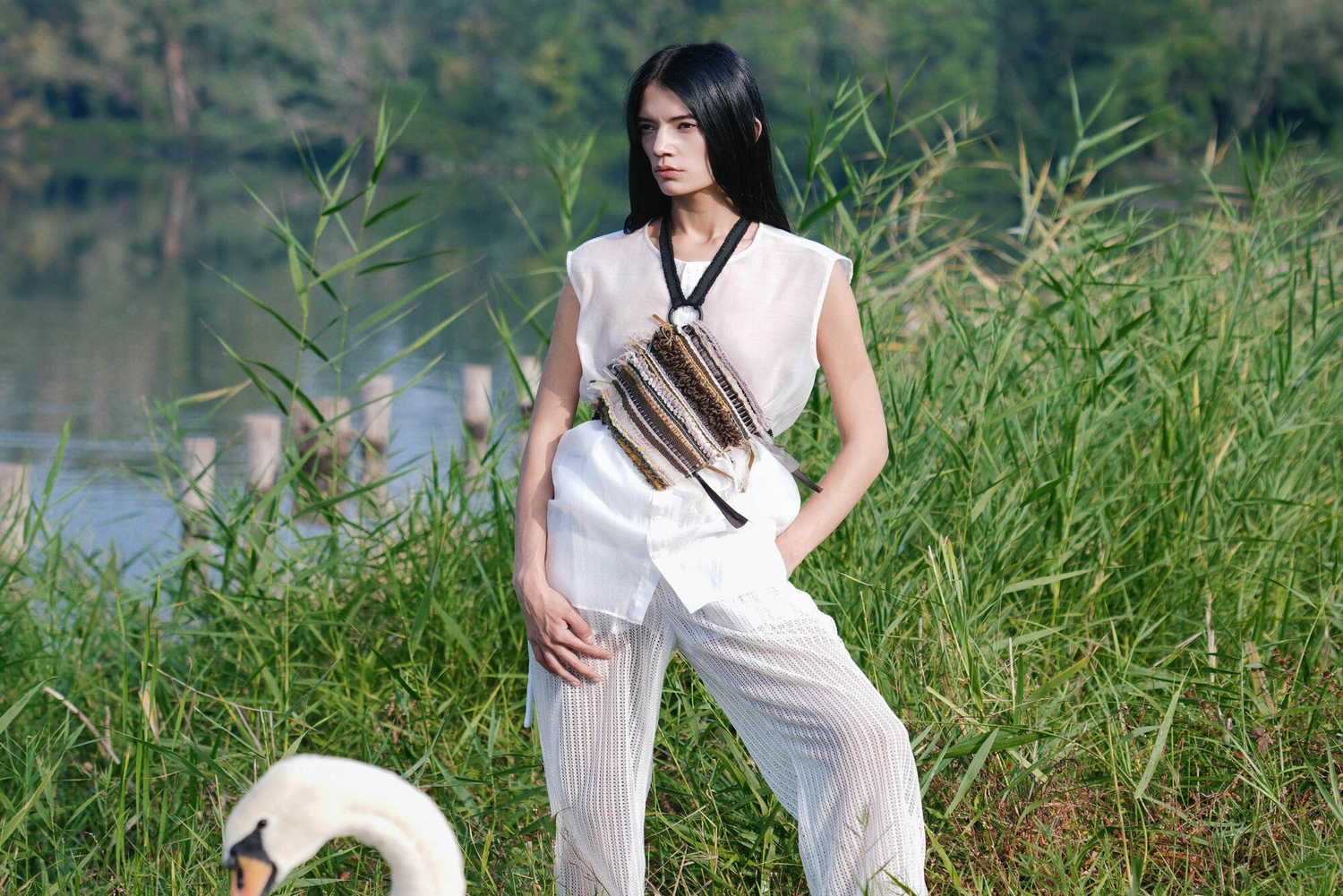 Model in white shirt with a MODEMENT Handwoven Dudou standing in a natural setting